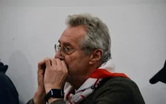 Nahaufnahme von Julijan vom Musikkreis. Er spielt Mundharmonika. 