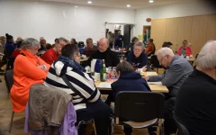 Besucher*innen der Adventsfeier an den Tischen