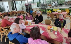 Die Teilnehmer*innen sitzen gemütlich an einem Tisch im Außenbereich&nbsp;der Orangerie