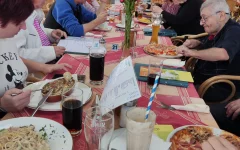 Das Warten hat ein Ende:&nbsp;Die Dienstagstreffler*innen genießen bei gutem Wetter&nbsp;Speisen und Getränke. Pizza, Nudeln und viele verschiedene Gerichte wurden bestellt.&nbsp;