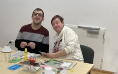 Rene und Melanie lächeln beim Basteln in die Kamera.