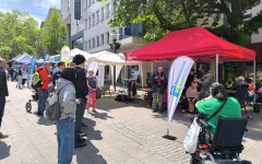 Foto des Auftritts der Band. Im Bild ist neben der Band und dem Publikum auch noch der gesamte Gemeinschaftsstand zu sehen.&nbsp;