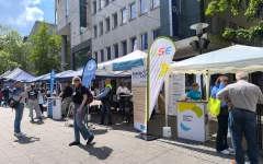 Foto des Gemeinschaftsstands: mehrere Pavillons mit Aufstellern der Träger und Stehtischen mit Informaterialien. Sichtbar sind die Logos der Lebenshilfe und GSE.&nbsp;