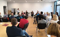 Hanna Fink moderiert die Veranstaltung. Sie steht neben dem Streichquartett.&nbsp;