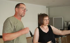  Michael Seifert und Angela Ströter im Gespräch beim Aufbau. Angela Ströter zeigt mit dem Arm nach vorne. 