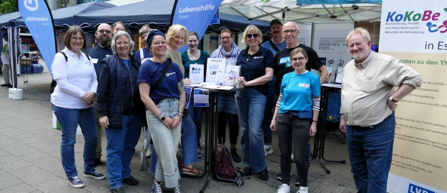 Gruppenfoto aller Beteiligten am Gemeinschaftsstand bei Essen Original. Alle lächeln in die Kamera. Sie stehen vor dem Stand, im Hintergrund sind Pavillons und Stehtische mit Infos zu sehen
